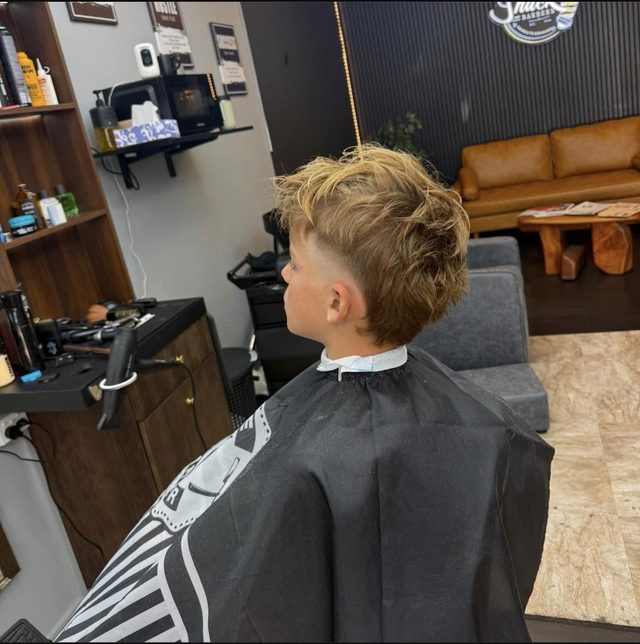 A young boy with a textured mullet fade in the chair at Fade Shack Barbers, Orewa.